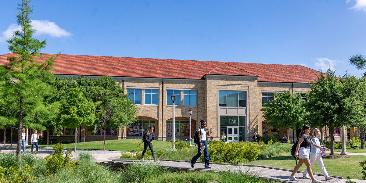 Students walking on TCU campus near fine arts building