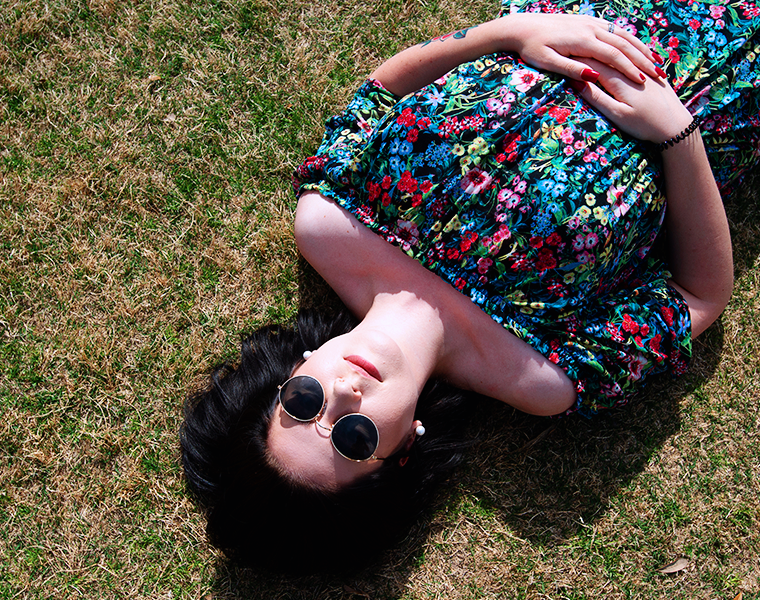 Female student relaxing while laying on the grass