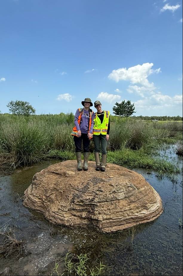Emma Solomon and her coworker on a rock formation in Taylor, Texas.