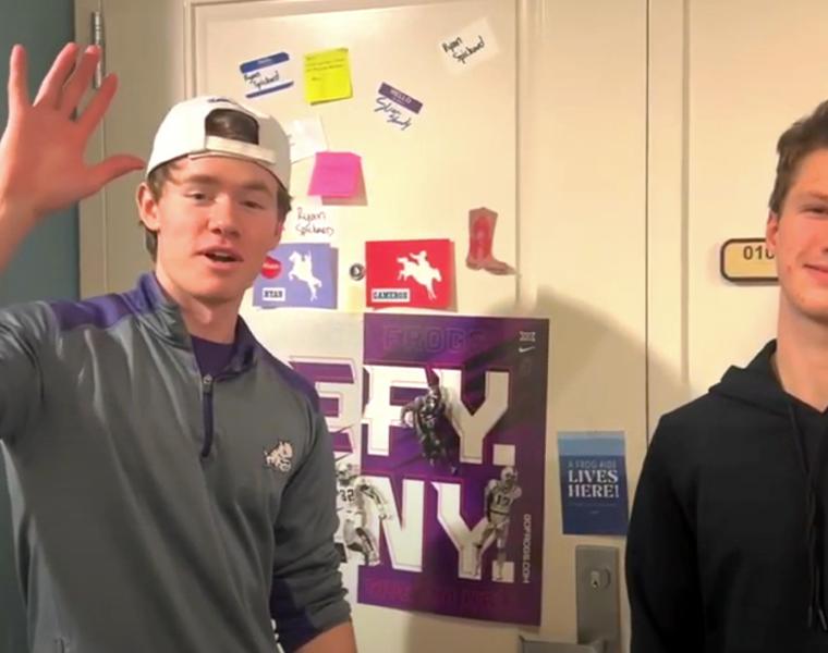two boys standing in front of decorated dorm room door
