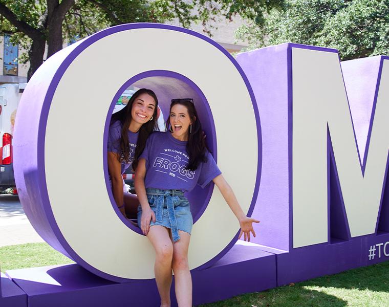 students smiling with large letters spelling HOME
