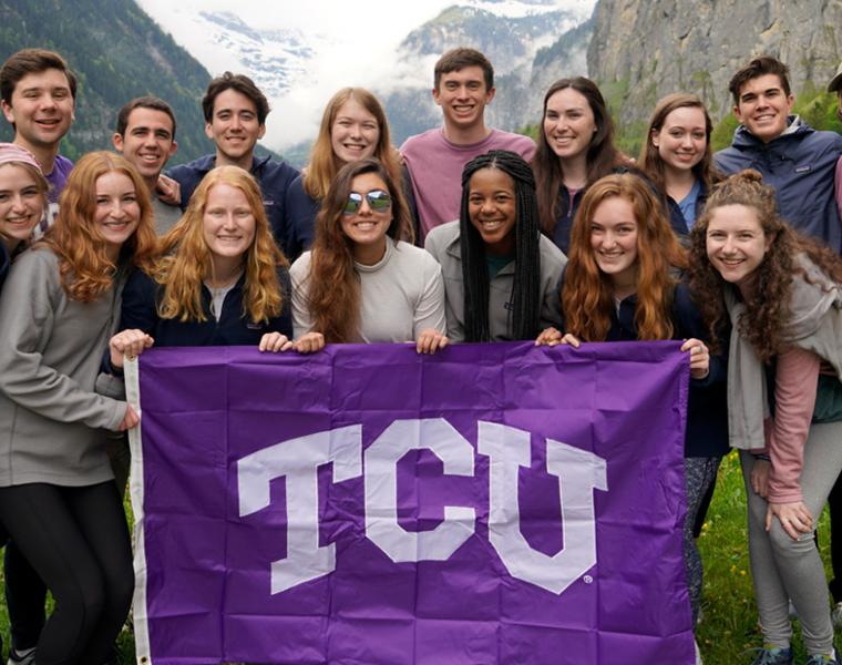 honors college students pose with a TCU flag while studying abroad