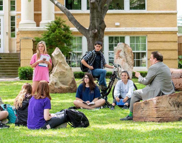 students and a professor gathered at frog henge for class