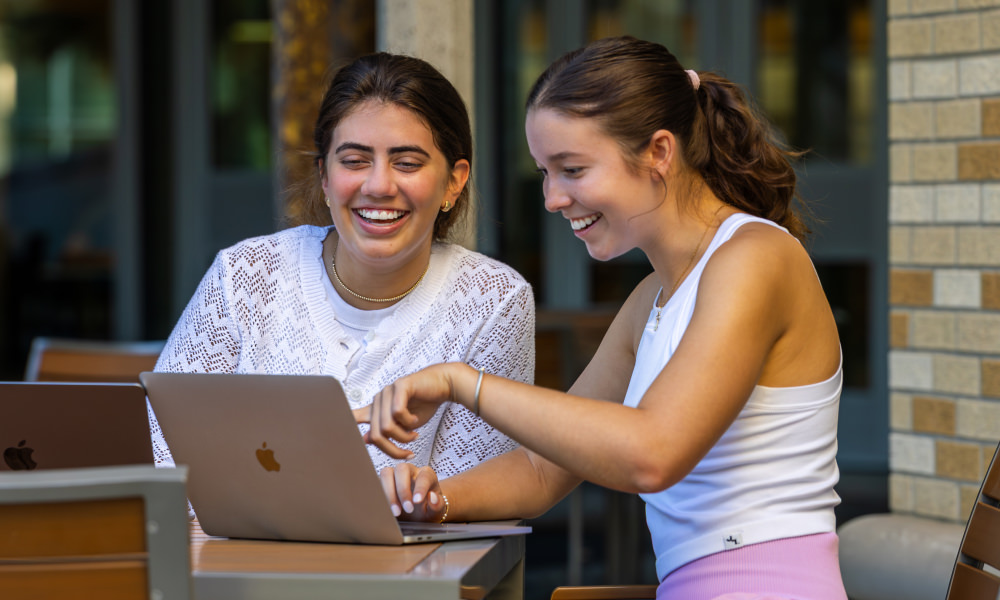 Two female students using laptop computer