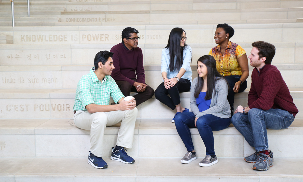 International students and professor hanging out on the library steps 